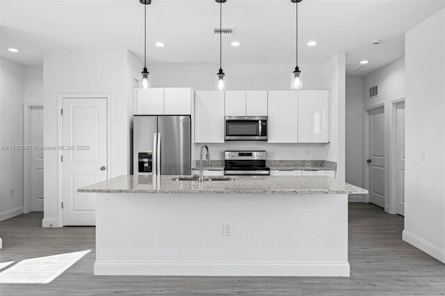933 Gleason St, Lehigh Acres, FL 33974 - kitchen with appliances with stainless steel finishes, white cabinets, light wood-style floors, a kitchen island with sink, and recessed lighting