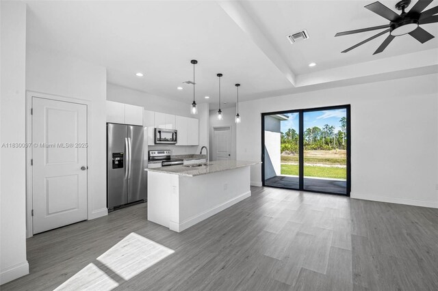 933 Gleason St, Lehigh Acres, FL 33974 - kitchen featuring appliances with stainless steel finishes, white cabinets, recessed lighting, an island with sink, and wood finished floors