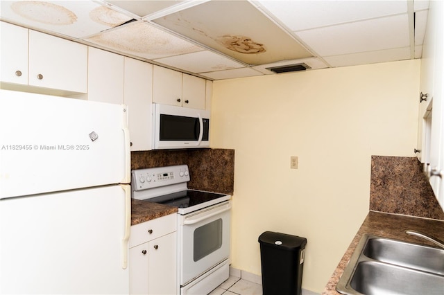 3719 Riverside Dr Unit 3719, Coral Springs, FL 33065 - kitchen with white appliances, a drop ceiling, dark countertops, white cabinetry, and decorative backsplash