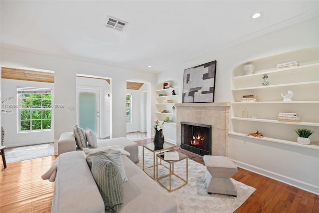 8325 NE 3rd Ave, Miami, FL 33138 - living room featuring crown molding, a high end fireplace, wood finished floors, built in shelves, and recessed lighting