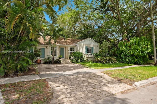 8325 NE 3rd Ave, Miami, FL 33138 - view of front of home with stucco siding, driveway, and a front lawn
