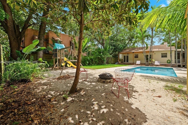 8325 NE 3rd Ave, Miami, FL 33138 - outdoor pool featuring a fire pit, a patio, and a playground