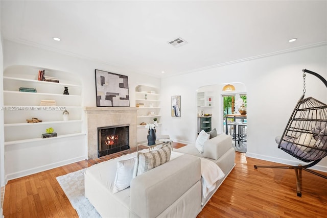 8325 NE 3rd Ave, Miami, FL 33138 - living room featuring built in features, ornamental molding, wood finished floors, a premium fireplace, and arched walkways