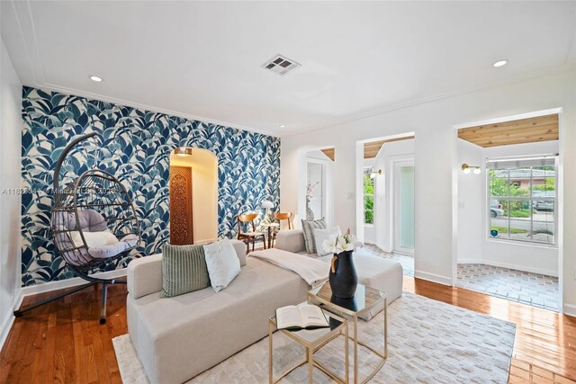 8325 NE 3rd Ave, Miami, FL 33138 - living room featuring wallpapered walls, ornamental molding, hardwood / wood-style floors, an accent wall, and arched walkways