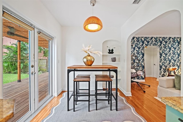 8325 NE 3rd Ave, Miami, FL 33138 - dining area with arched walkways, wood finished floors, wallpapered walls, and built in features