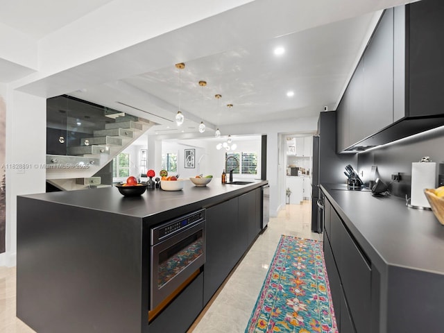 1117 Alberca St, Coral Gables, FL 33134 - kitchen with dark cabinets, dark countertops, wall oven, modern cabinets, and a spacious island
