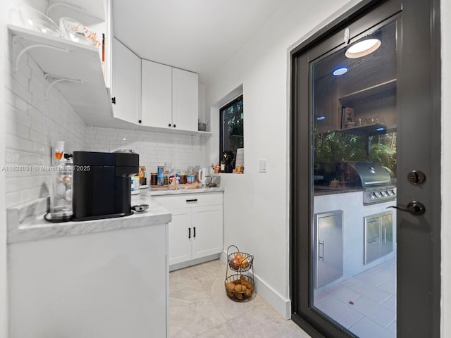 1117 Alberca St, Coral Gables, FL 33134 - kitchen with tasteful backsplash, white cabinets, and light countertops