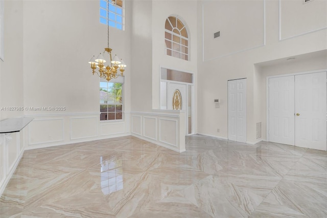 6201 Floridian Cir, Lake Worth, FL 33463 - unfurnished room with a high ceiling, a chandelier, and a decorative wall