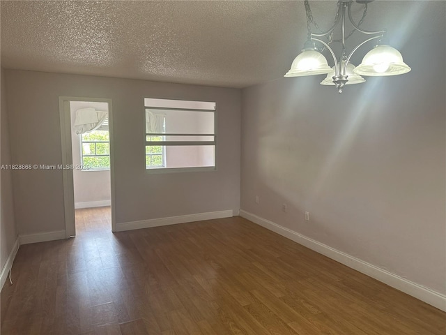 251 Galen Dr Unit 112E, Key Biscayne, FL 33149 - empty room with a chandelier, wood finished floors, and a textured ceiling