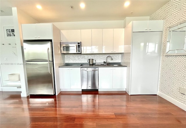 935 Euclid Ave Unit 7, Miami Beach, FL 33139 - kitchen with appliances with stainless steel finishes, dark wood-type flooring, white cabinetry, dark countertops, and wallpapered walls