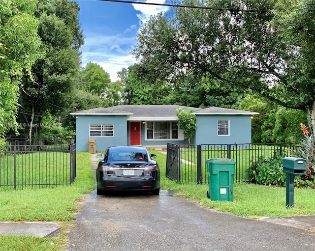 5221 Orange Dr, Davie, FL 33314 - view of front of property with driveway, a fenced front yard, stucco siding, and roof with shingles