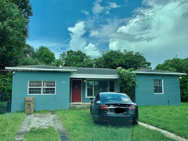 5221 Orange Dr, Davie, FL 33314 - view of front facade featuring stucco siding, a front lawn, and a shingled roof