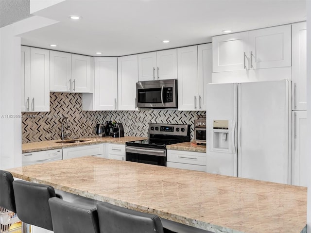 20401 NE 30th Ave Unit 310-8, Aventura, FL 33180 - kitchen with stainless steel appliances, white cabinets, a breakfast bar area, and recessed lighting