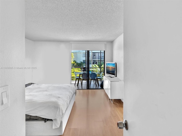 20401 NE 30th Ave Unit 310-8, Aventura, FL 33180 - bedroom with wood finished floors, a textured ceiling, and access to exterior