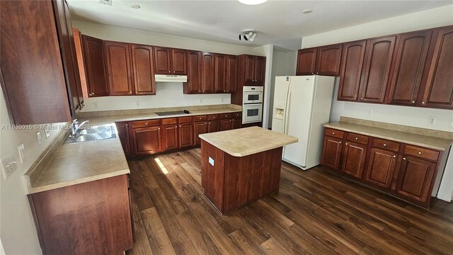 4407 Karlbrook Ln, ,, NC 27616 - kitchen with white appliances, under cabinet range hood, dark wood-style flooring, light countertops, and a center island