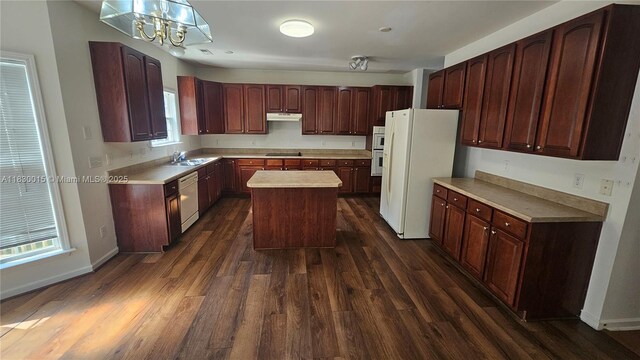4407 Karlbrook Ln, ,, NC 27616 - kitchen with white appliances, dark wood-style flooring, under cabinet range hood, a center island, and light countertops