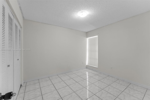 6908 SW 104th Ct, Miami, FL 33173 - unfurnished bedroom featuring a textured ceiling, a closet, and light tile patterned flooring