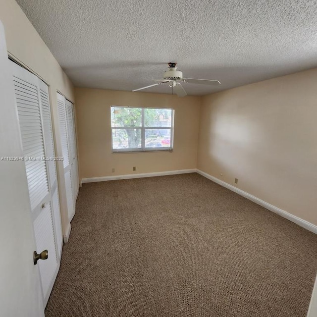 4163 NW 90th Ave Unit 206, Coral Springs, FL 33065 - unfurnished bedroom featuring two closets, a textured ceiling, carpet, and ceiling fan