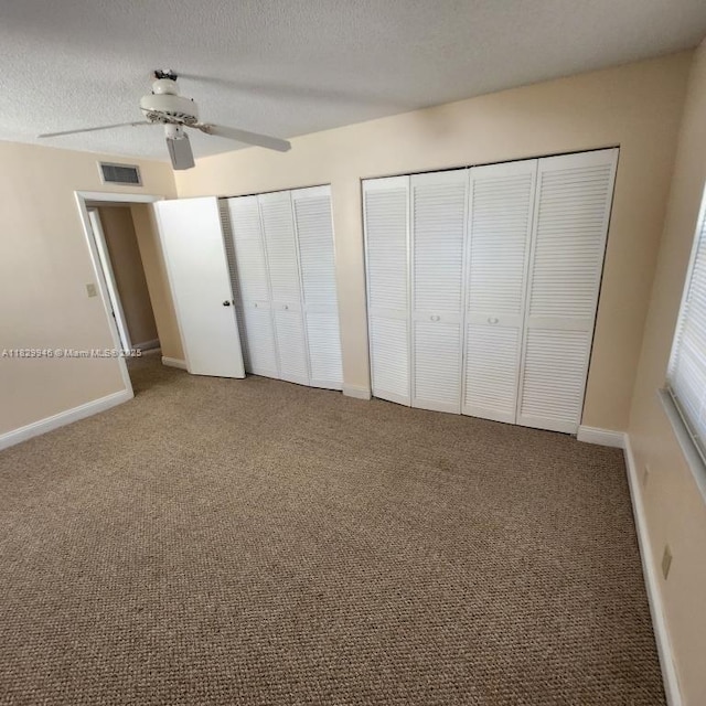 4163 NW 90th Ave Unit 206, Coral Springs, FL 33065 - unfurnished bedroom featuring two closets, carpet floors, a textured ceiling, and ceiling fan
