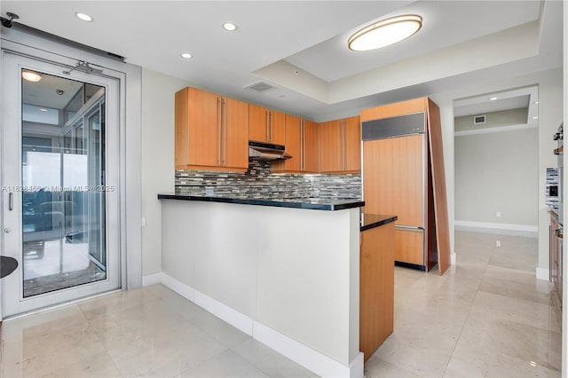 1425 Brickell Ave Unit 44A-B, Miami, FL 33131 - kitchen with paneled built in fridge, dark countertops, a raised ceiling, and recessed lighting
