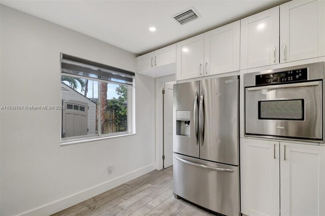 1840 N 56th Ave, Hollywood, FL 33021 - kitchen featuring appliances with stainless steel finishes, light wood-style flooring, white cabinets, and recessed lighting
