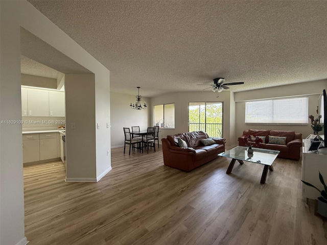 1400 SW 137th Ave Unit 411F, Pembroke Pines, FL 33027 - living room featuring a textured ceiling, a ceiling fan, light wood-type flooring, and a chandelier