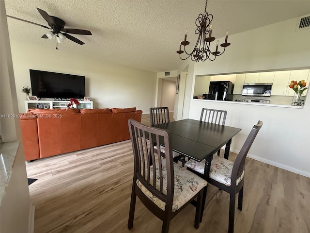 1400 SW 137th Ave Unit 411F, Pembroke Pines, FL 33027 - dining area with light wood finished floors, a textured ceiling, a chandelier, and a ceiling fan