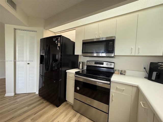 1400 SW 137th Ave Unit 411F, Pembroke Pines, FL 33027 - kitchen with appliances with stainless steel finishes, light wood-style flooring, light countertops, and a textured ceiling