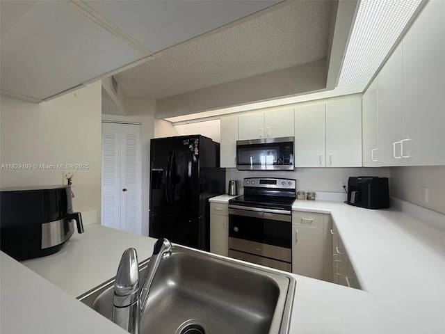 1400 SW 137th Ave Unit 411F, Pembroke Pines, FL 33027 - kitchen featuring appliances with stainless steel finishes, light countertops, white cabinets, and a textured ceiling