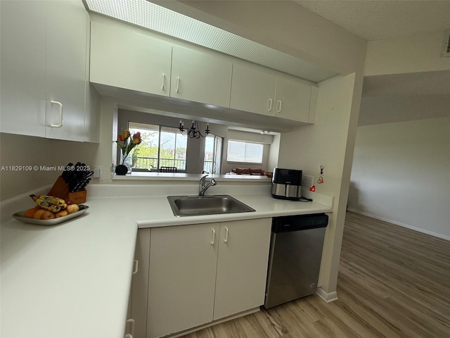 1400 SW 137th Ave Unit 411F, Pembroke Pines, FL 33027 - kitchen featuring stainless steel dishwasher, light wood-type flooring, light countertops, white cabinetry, and a chandelier
