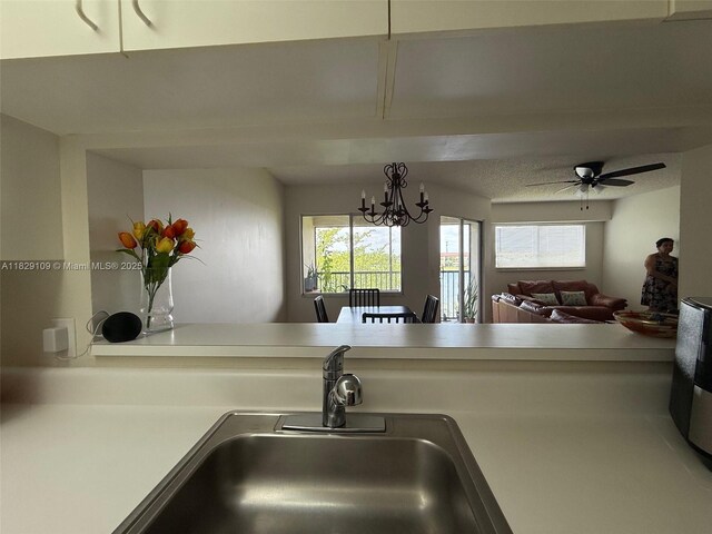 1400 SW 137th Ave Unit 411F, Pembroke Pines, FL 33027 - kitchen view of light countertops, a ceiling fan, and a chandelier
