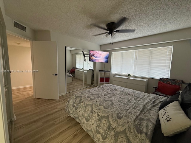 1400 SW 137th Ave Unit 411F, Pembroke Pines, FL 33027 - bedroom with wood finished floors, a textured ceiling, a closet, and a ceiling fan