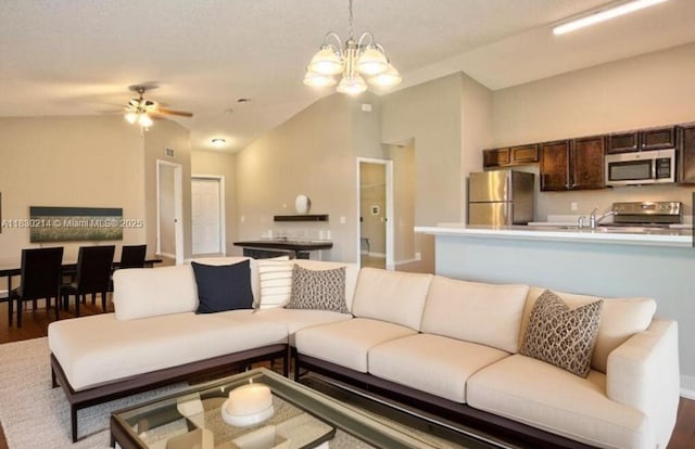 3574 SW Masilunas St, Port St Lucie, FL 34953 - living area with a chandelier, wood finished floors, ceiling fan, and lofted ceiling
