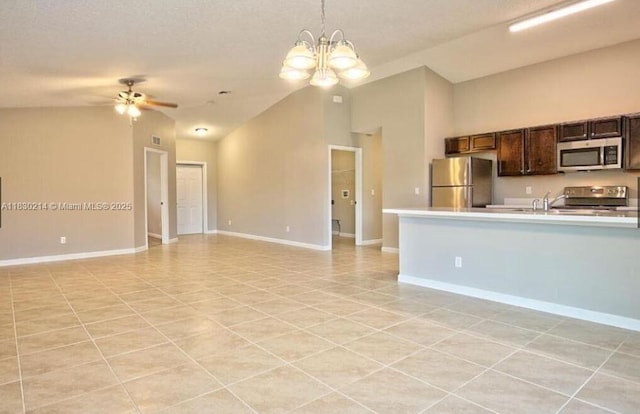 3574 SW Masilunas St, Port St Lucie, FL 34953 - kitchen featuring stainless steel appliances, open floor plan, light countertops, light tile patterned floors, and vaulted ceiling