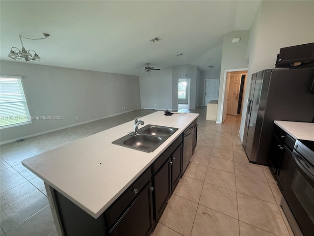 3574 SW Masilunas St, Port St Lucie, FL 34953 - kitchen featuring open floor plan, vaulted ceiling, light tile patterned floors, light countertops, and a kitchen island with sink