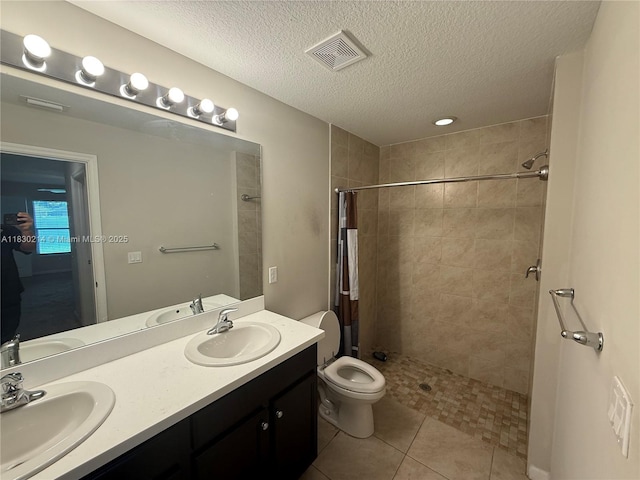3574 SW Masilunas St, Port St Lucie, FL 34953 - full bath featuring double vanity, a tile shower, a textured ceiling, and tile patterned flooring