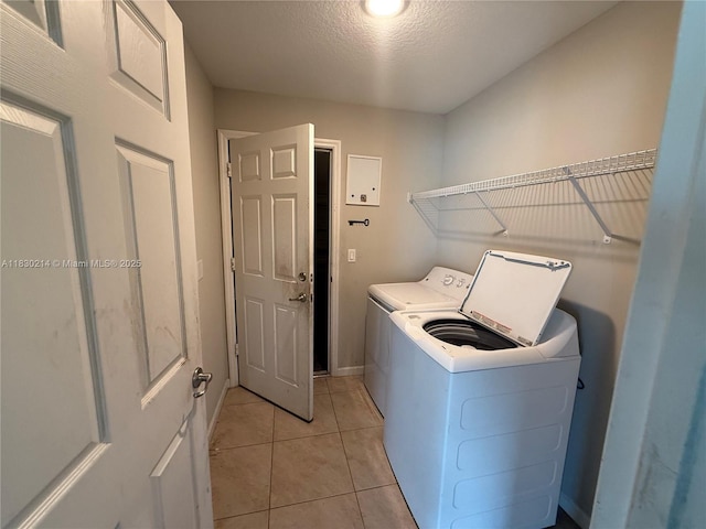 3574 SW Masilunas St, Port St Lucie, FL 34953 - laundry room with washing machine and clothes dryer, light tile patterned floors, and a textured ceiling