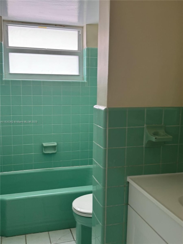 3500 Harrison St Unit 10, Hollywood, FL 33021 - full bathroom featuring tile patterned floors, tile walls, a bath, vanity, and wainscoting