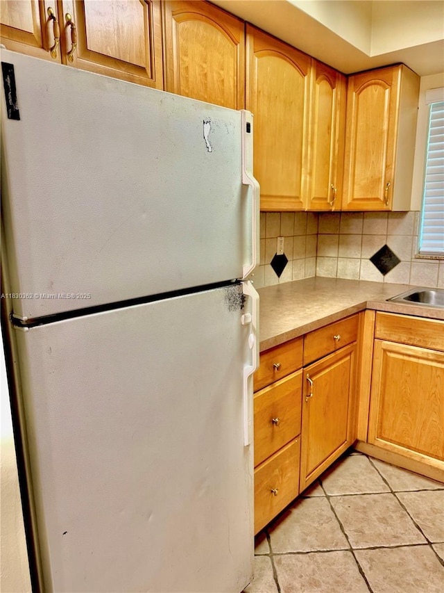 3500 Harrison St Unit 10, Hollywood, FL 33021 - kitchen featuring freestanding refrigerator, backsplash, light tile patterned floors, and light countertops
