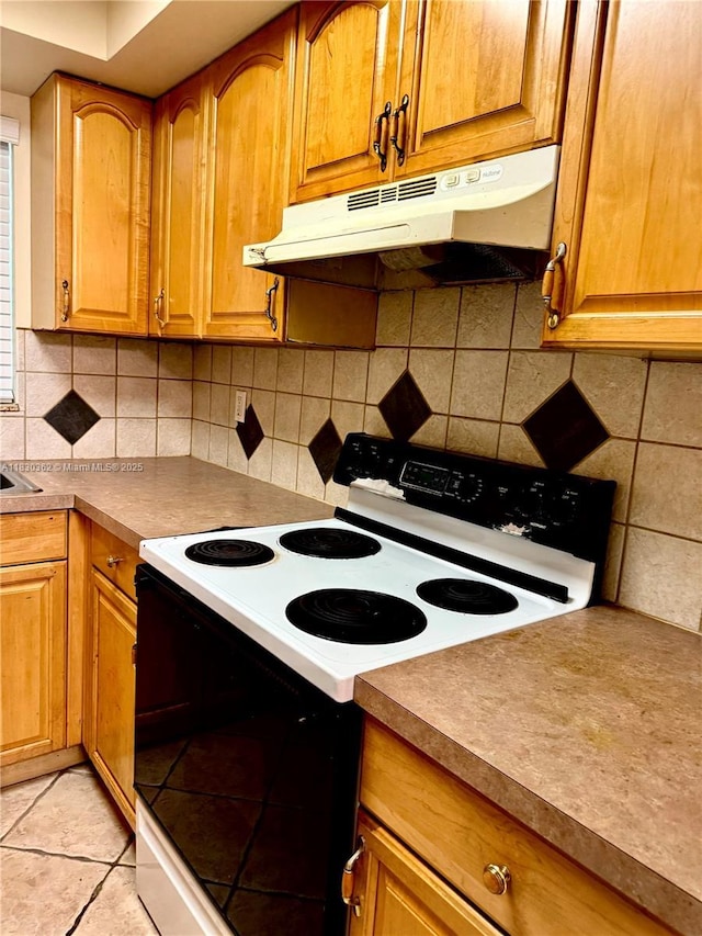 3500 Harrison St Unit 10, Hollywood, FL 33021 - kitchen with range with electric cooktop, under cabinet range hood, tasteful backsplash, and brown cabinets