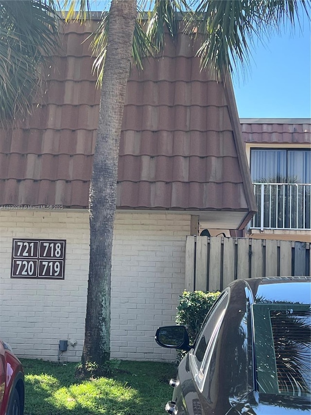 719 Mill Valley Pl, West Palm Beach, FL 33409 - view of side of property featuring brick siding, mansard roof, and a garage