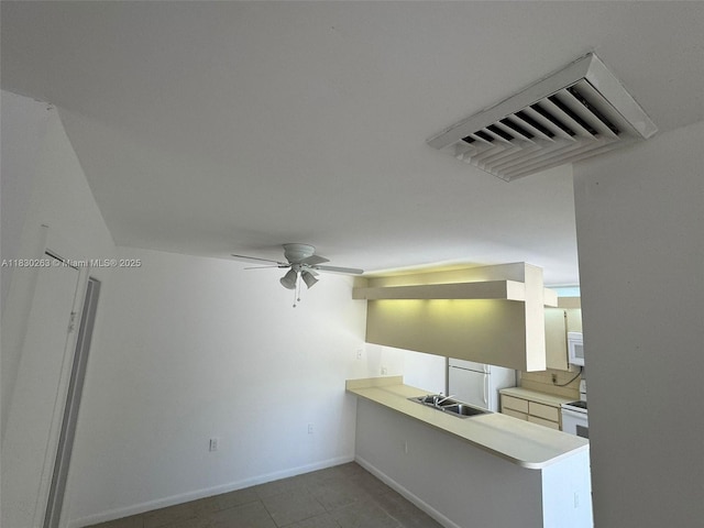 719 Mill Valley Pl, West Palm Beach, FL 33409 - kitchen with light countertops, a peninsula, ceiling fan, white appliances, and tile patterned flooring