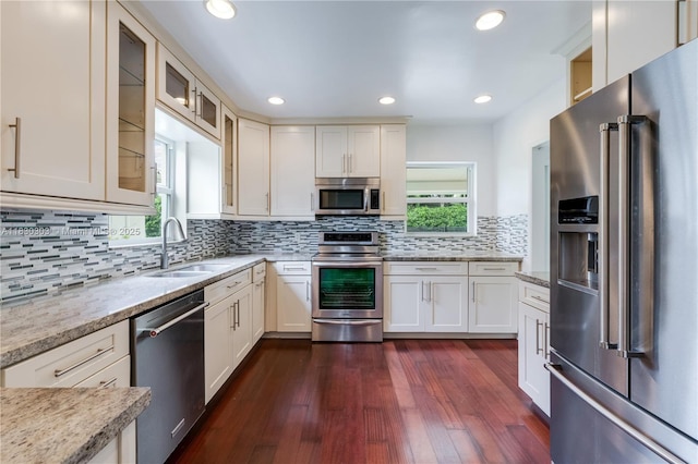 431 Gerona Ave, Coral Gables, FL 33146 - kitchen featuring appliances with stainless steel finishes, glass insert cabinets, dark wood-type flooring, backsplash, and white cabinetry