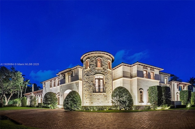 10101 SW 60th Ct, Pinecrest, FL 33156 - mediterranean / spanish-style home with curved driveway, stone siding, and stucco siding