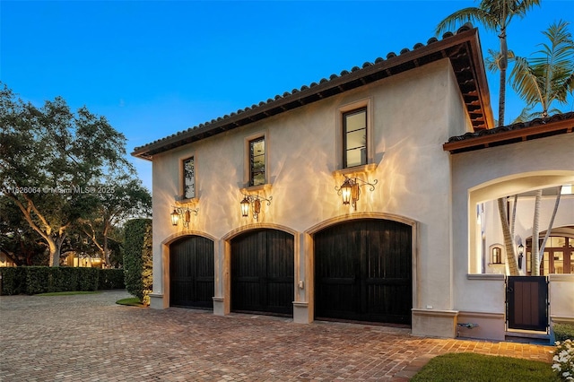 10101 SW 60th Ct, Pinecrest, FL 33156 - view of front of property with decorative driveway, stucco siding, and an attached garage