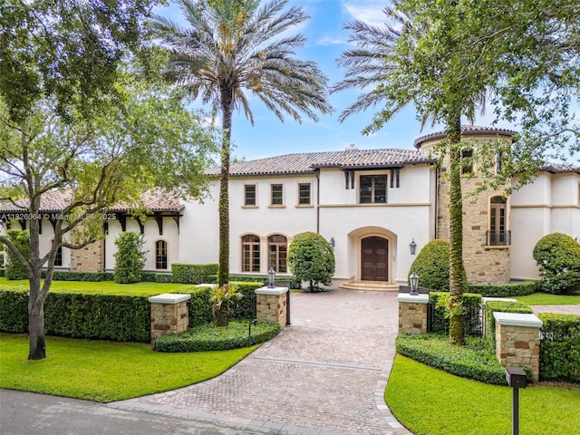 10101 SW 60th Ct, Pinecrest, FL 33156 - mediterranean / spanish home featuring a tile roof, stucco siding, decorative driveway, and a front yard