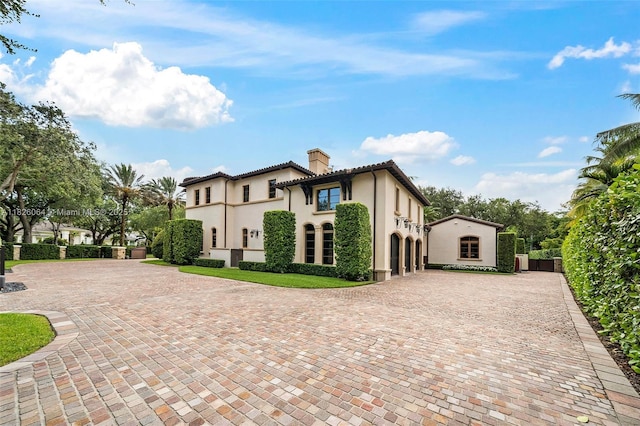 10101 SW 60th Ct, Pinecrest, FL 33156 - mediterranean / spanish home with a chimney, stucco siding, curved driveway, and a tiled roof