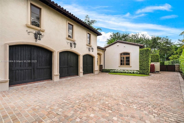 10101 SW 60th Ct, Pinecrest, FL 33156 - mediterranean / spanish home with stucco siding, decorative driveway, a garage, and a gate
