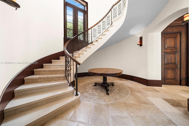 10101 SW 60th Ct, Pinecrest, FL 33156 - stairs featuring arched walkways, stone finish floors, and a towering ceiling