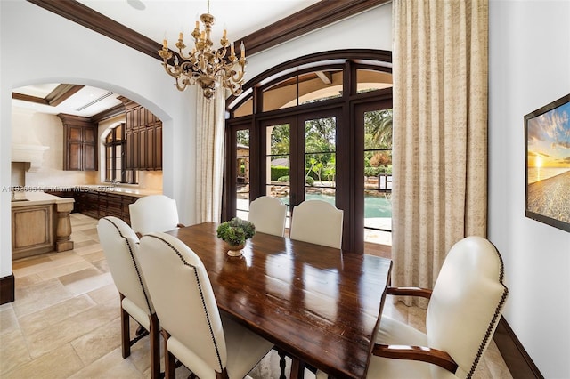 10101 SW 60th Ct, Pinecrest, FL 33156 - dining room featuring arched walkways, ornamental molding, a chandelier, light stone finish floors, and french doors